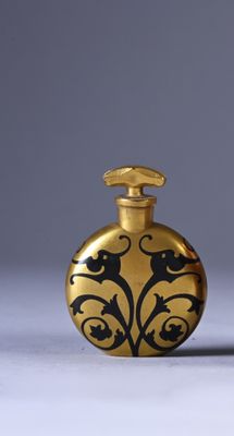 gold flaskt with black and white designs on it sitting on a white surface