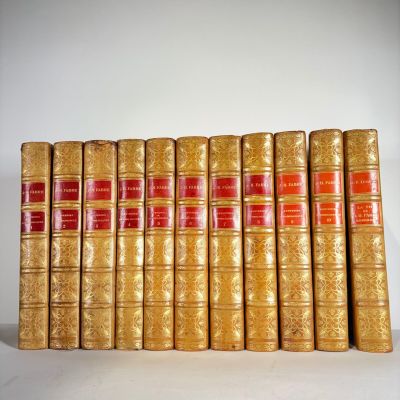 several old books are lined up on a white surface