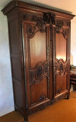 a large wooden armoire in the corner of a room