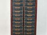 une vieille armoire en bois surmontée de nombreux tiroirs