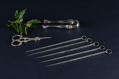 five pairs of scissors and a pair of scissors on a table
