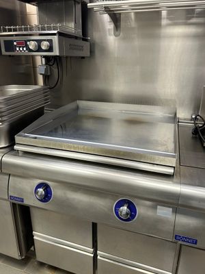 plan de travail en acier inoxydable dans une cuisine commerciale équipée d'appareils en acier inoxydable