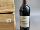 a bottle of red wine sitting next to a wooden box