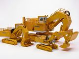 une maquette jaune d'un bulldozer et un bulldozer