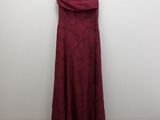 a red dress hanging on a hanger against a white wall