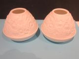two white vases sitting on a blue table