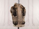 a fur vest on a mannequin stand in front of a wall