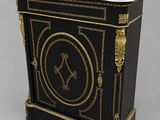 un meuble ancien peint en noir et or, avec un plateau en marbre