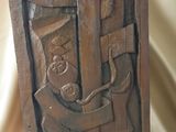 plaque en bois sculptée représentant un homme tenant un enfant dans ses bras