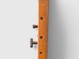 a close up of a wooden instrument on a white surface
