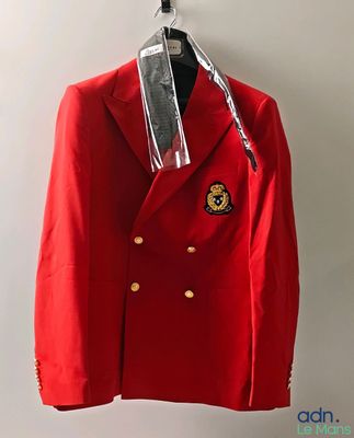 un blazer rouge suspendu à un cintre sur un mur blanc