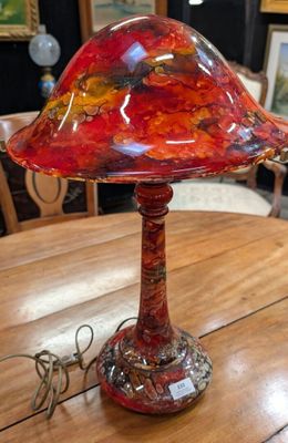 une lampe rouge posée sur une table en bois
