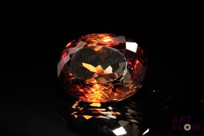 un gros plan d'un diamant aux couleurs chatoyantes posé sur une surface noire