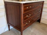a dresser with a marble top and a red vase on top of it