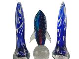 trois figurines de poissons en verre posées les unes à côté des autres