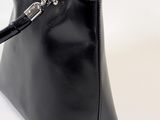 black leather handbag on a white background with a chain
