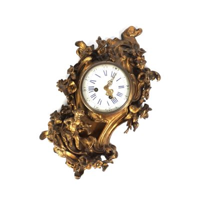 une horloge dorée sur un mur blanc, avec un fond blanc