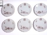 six assiettes ornées de motifs floraux sont disposées sur un fond blanc