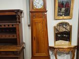 une horloge de parquet posée à côté d'une table sur laquelle se trouve un miroir
