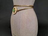 a close up of a mannequin torso with a green and gold bracelet