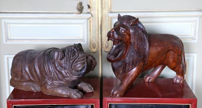 des sculptures représentant un lion et un chien sont exposées devant un miroir
