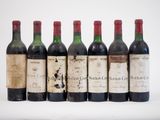 six bouteilles de vin sont alignées sur une surface blanche