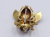 a gold plated brooch with a bee on it