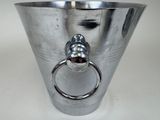 a silver vase with a ring in it on a table