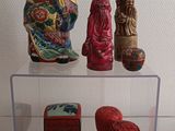 une vitrine en verre sur laquelle sont exposées diverses figurines asiatiques