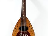 an old wooden mandolin sitting on top of a white surface