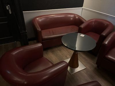 des fauteuils en cuir et une table dans une pièce aux murs noirs