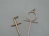 a pair of cross earrings on a gray surface