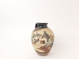 a small vase with a painting on it sitting on a table