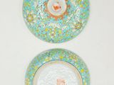two plates with designs on them sitting on a white surface