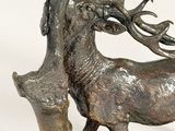 bronze sculpture of a stag with antlers on a rock