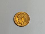 gros plan d'une pièce d'or sur une surface blanche