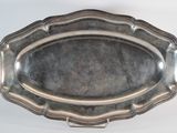 a silver tray with a silver handle on a white surface