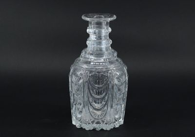 une bouteille en verre transparent posée sur une surface noire
