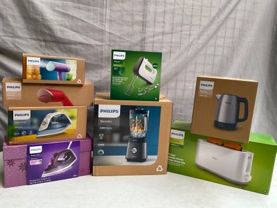 plusieurs cartons contenant des appareils électroménagers posés sur une table devant un fond blanc