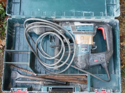une boîte à outils contenant des outils, posée sur le sol