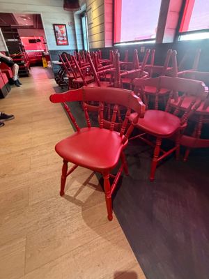 de nombreuses chaises rouges alignées en rang dans un restaurant