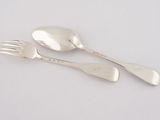 two silver spoons and a fork on a white surface