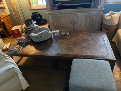 un canapé et un pouf dans un salon équipé d'une télévision à écran plat