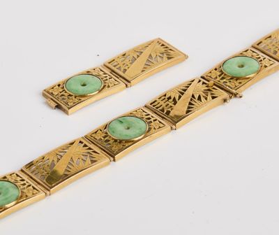 un gros plan sur deux bracelets en or ornés de pierres vertes