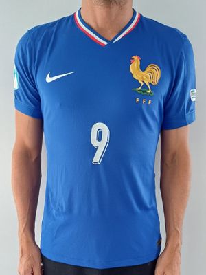 Cet homme porte une chemise bleue sur laquelle est représenté un coq.