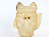a small carved owl figurine on a white surface