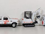 several toy trucks are lined up in a row on a white surface