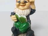 a gnome that is sitting on a rock with a book
