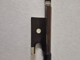 a violin bow and a bow rest on a white surface