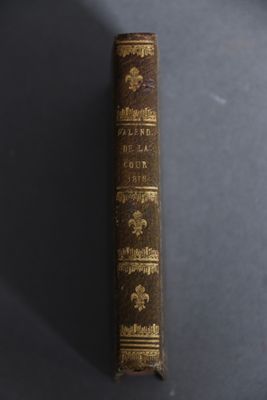an old book sitting on top of a table next to a black table